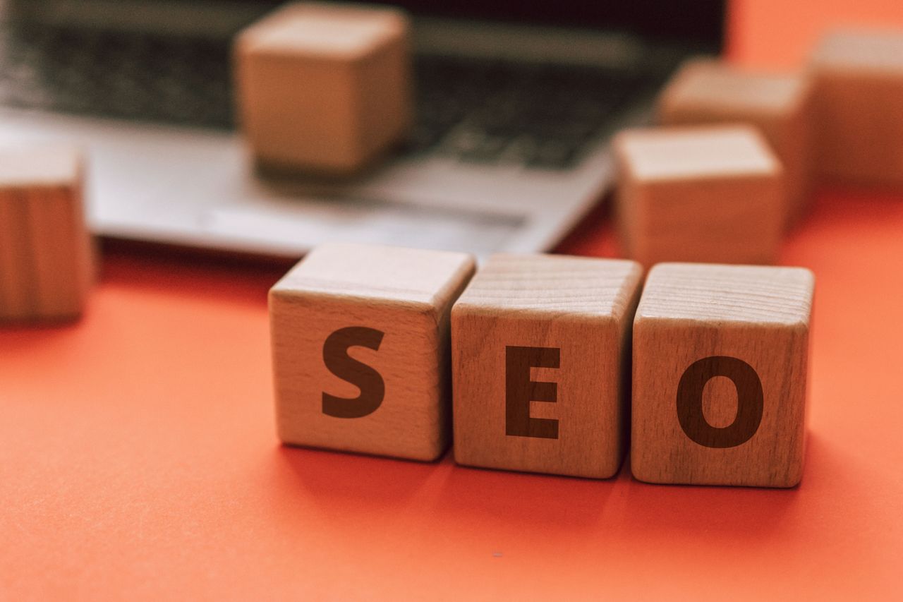 services-02 Des blocs en bois formant SEO sur le clavier d'un ordinateur portable illustrent des notions de marketing digital.